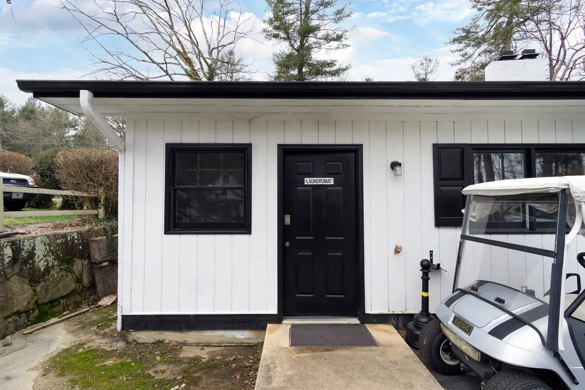 A practical view showing the laundry room door and a golf cart parked nearby, set against leafy greenery. This down-to-earth scene highlights convenient on-site amenities that make stays easy and stress-free.
